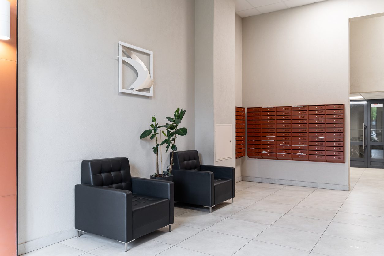 Open-concept mailroom with shelving, modern lighting, and clean finishes in a multifamily building