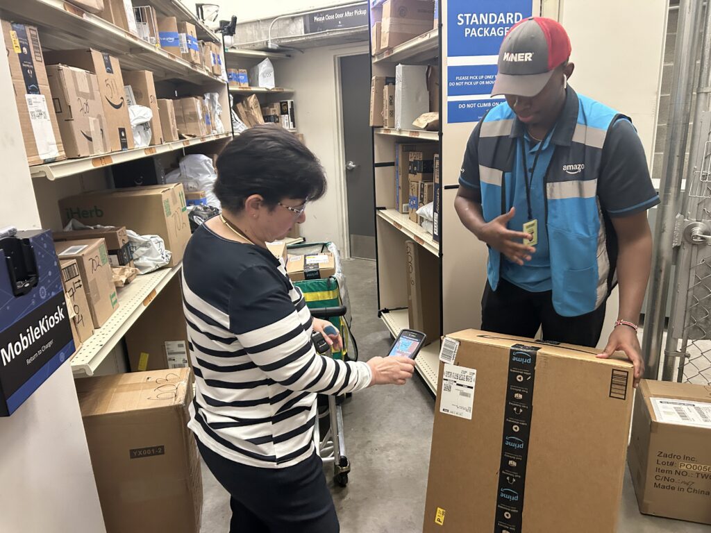 Property staff using the MobileKiosk™ to scan a package as a courier delivers oversized parcels into a smart package room