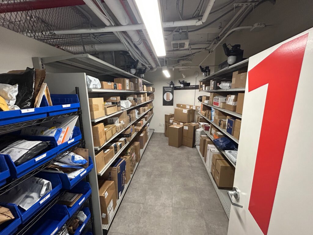 Inside a Smart Package Room solution at StuyTown showing open shelving lined with packages and parcels of various sizes
