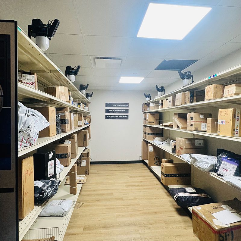 Smart Package Room system with open shelving full of resident packages during a summer move-in surge