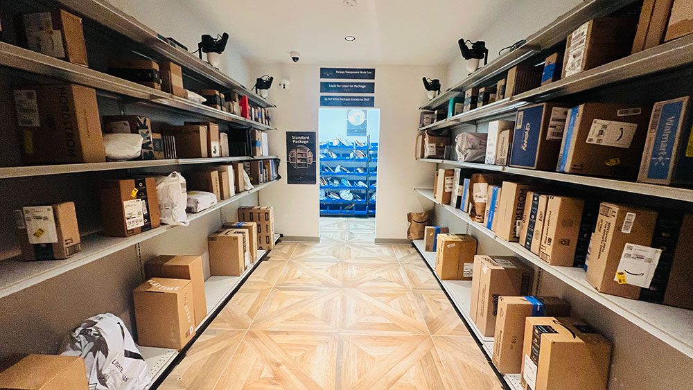 Standard package zone in a Smart Package Room with open shelving and flat package bins beyond the doorway