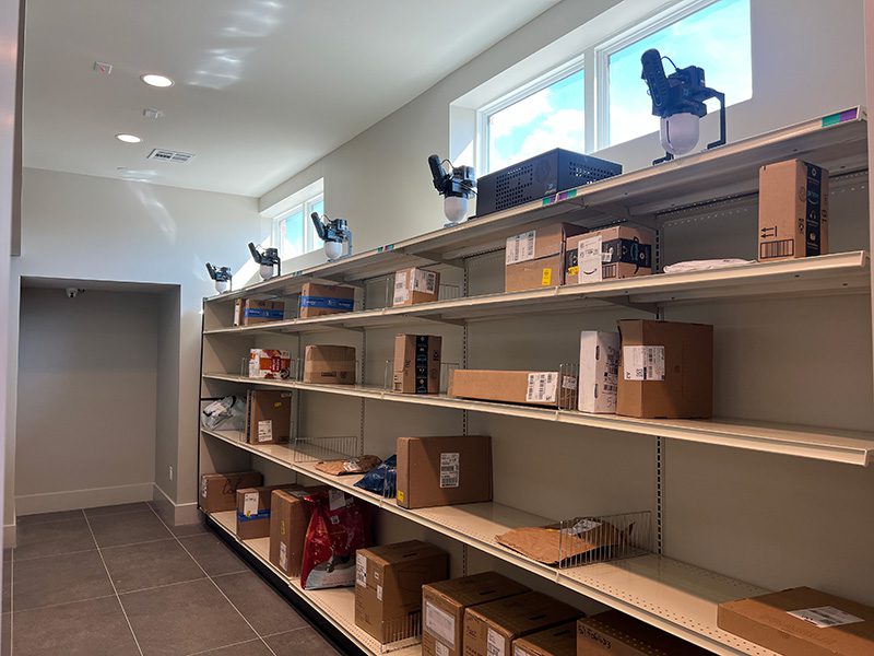 Amoeba Modules mounted above open shelves holding standard packages of varied sizes in a Smart Package Room